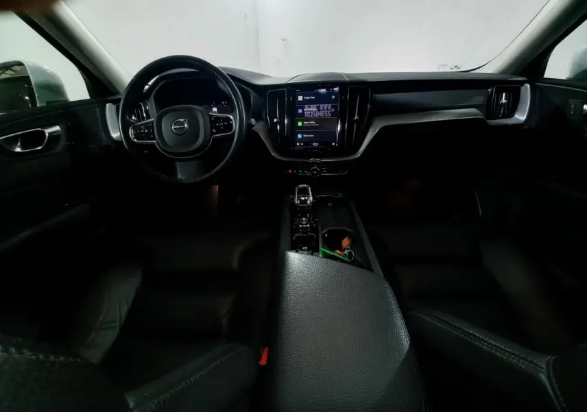 Intérieur noir du Volvo XC60 B4 2022 vu de face, avec tableau de bord tactile et volant multifonctions.
