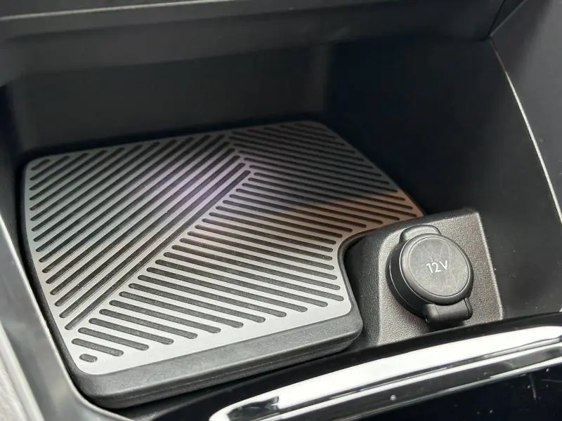 Gros plan sur la prise 12V et le tapis antidérapant noir dans le rangement central du Citroën C4 X 2025.