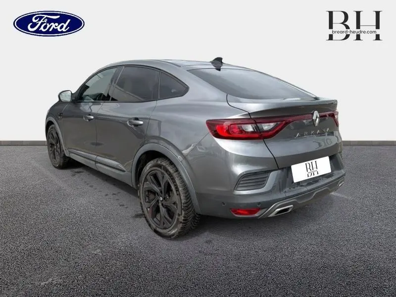 Vue 3/4 arrière droite d'une Renault Arkana gris métallisé avec feux LED et double sortie d'échappement.