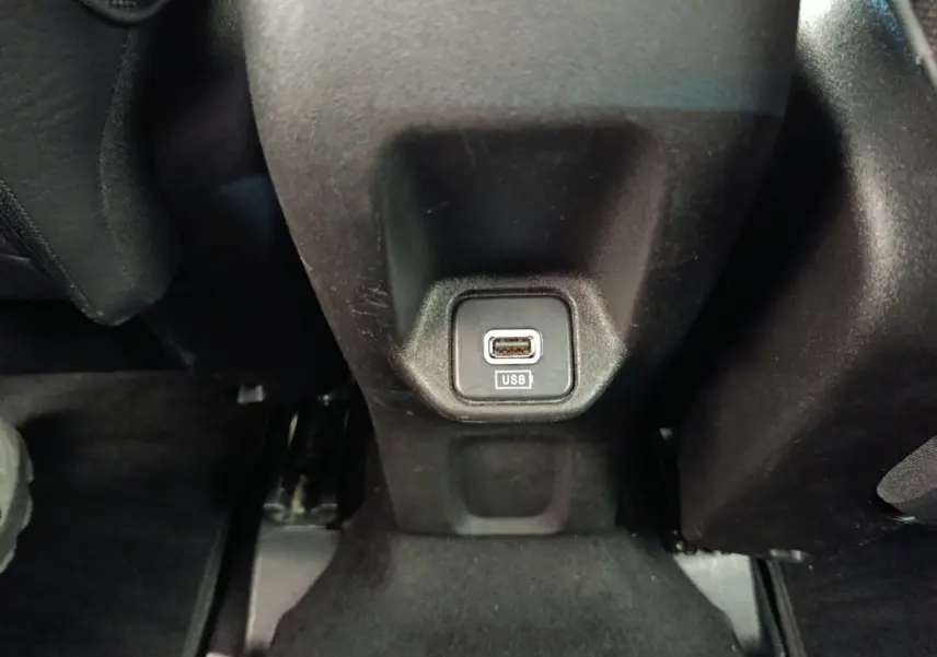 Prise USB noire en gros plan au bas de la console centrale arrière d’un Fiat 500X blanc, intérieur sombre.