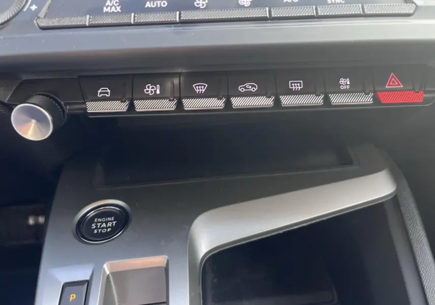 Vue rapprochée de la console centrale de la Peugeot 308 2024 avec boutons de commande et bouton start/stop.