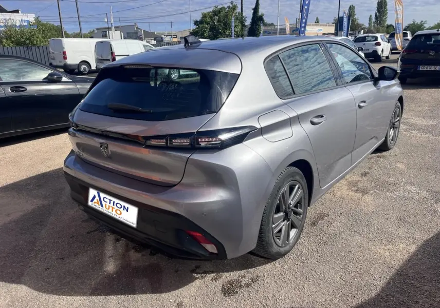 Peugeot 308 gris Artense vue 3/4 arrière droit, feux arrière LED et jantes alliage visibles en extérieur.