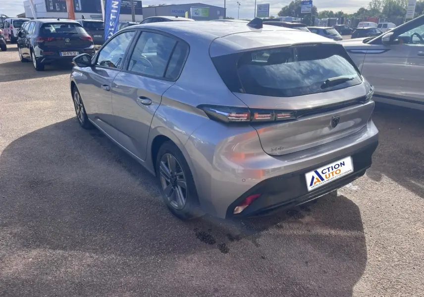 Peugeot 308 gris Artense vue 3/4 arrière droit, feux arrière LED et jantes alu visibles sur parking extérieur.