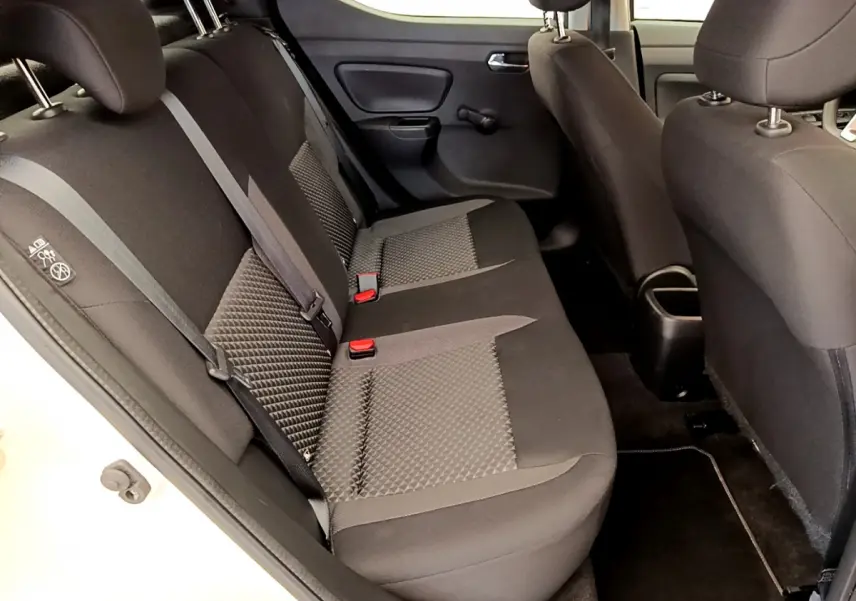 Vue intérieure côté gauche montrant la banquette arrière noire et grise de la Nissan Micra IG-T 92 Acenta blanche.