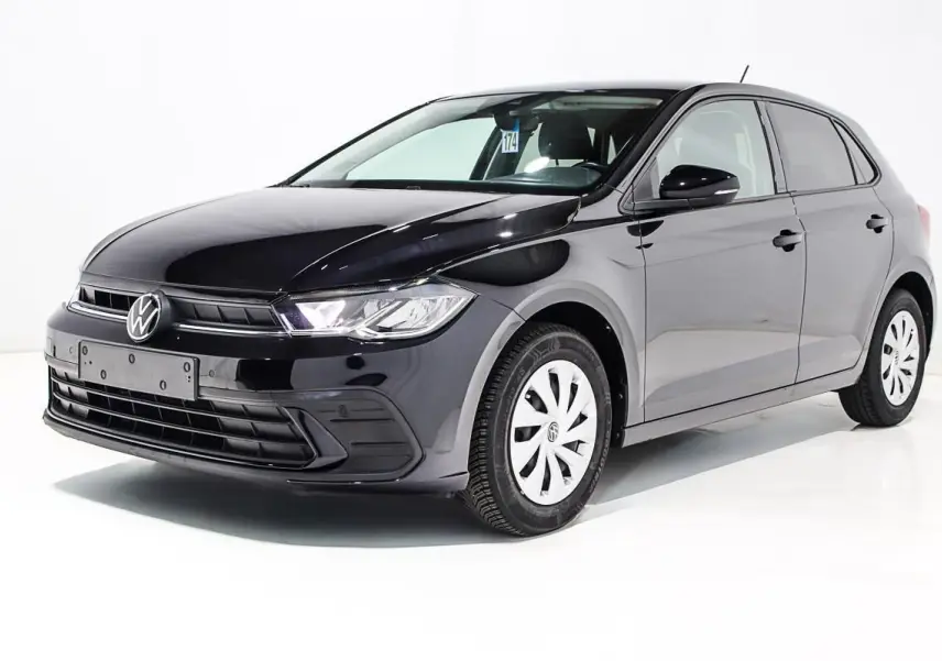Volkswagen Polo noire vue en 3/4 avant droit, avec jantes blanches et phares allumés sur fond blanc.