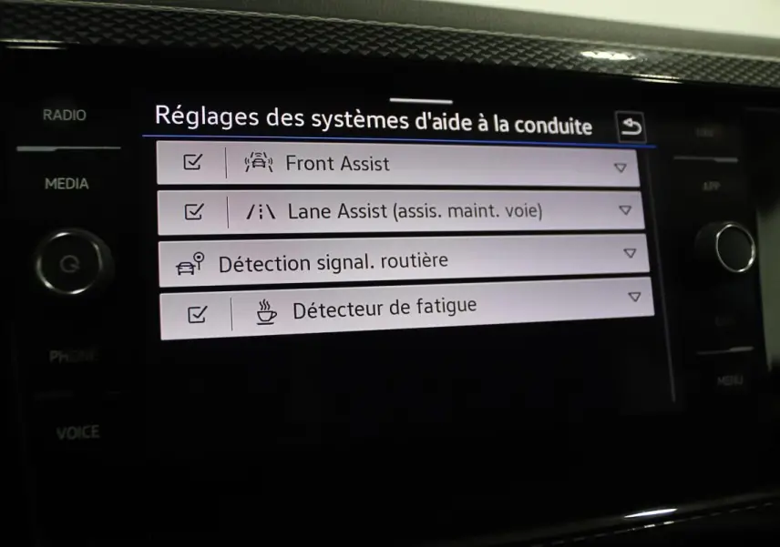 Écran tactile intérieur affichant les réglages des aides à la conduite sur Volkswagen Polo noire 2022.