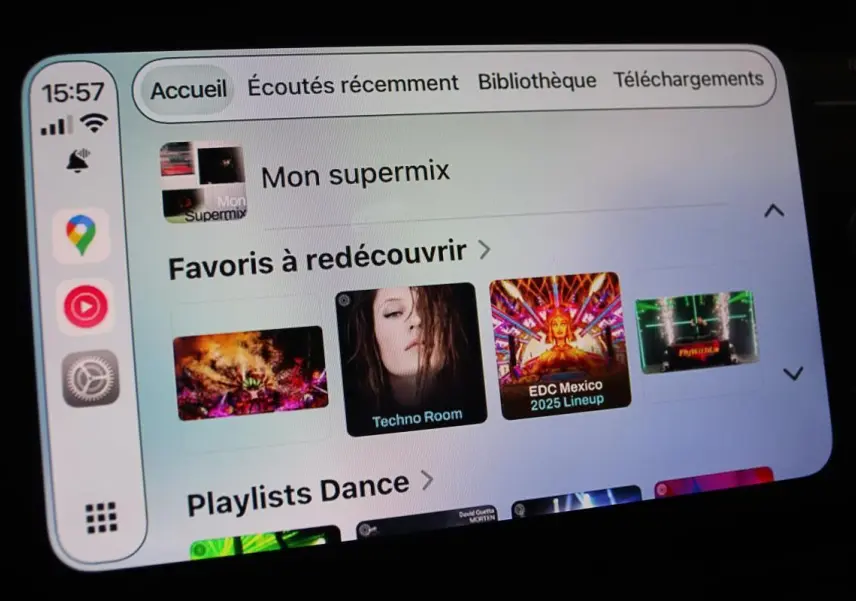 Écran tactile du système Apple CarPlay affichant une playlist musicale dans une Volkswagen Polo noire de 2022.