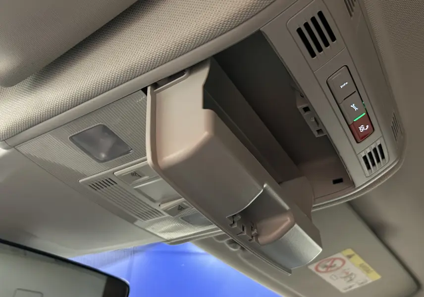 Détail du rangement plafond ouvert dans l’habitacle clair d’une Volkswagen Polo noire de 2022.