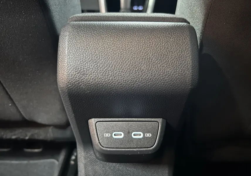 Vue rapprochée des ports USB-C pour recharge situés à l'arrière de la console centrale d'une Volkswagen Polo noire.