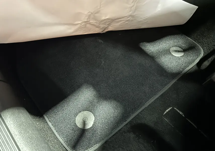 Vue rapprochée du tapis de sol noir côté conducteur d’une Volkswagen Polo 2022, avec fixation circulaire visible.