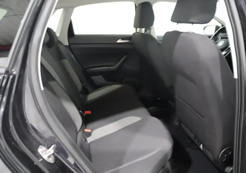 Vue intérieure montrant les sièges arrière en tissu gris et noir d'une Volkswagen Polo noire de 2022, porte arrière ouverte.