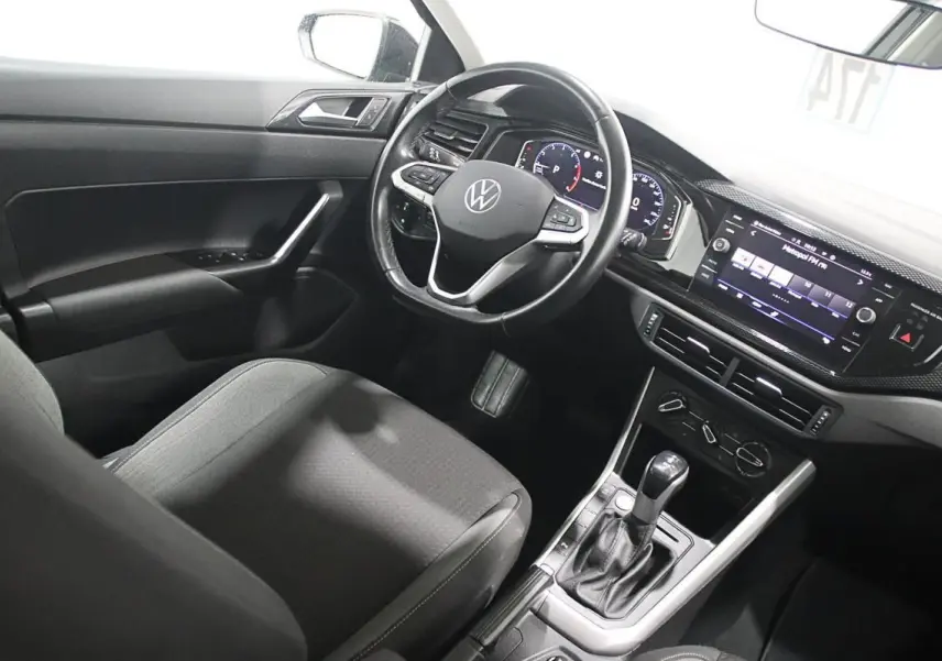 Intérieur de la Volkswagen Polo 2022 vu côté conducteur, avec volant multifonction et écran tactile allumé.