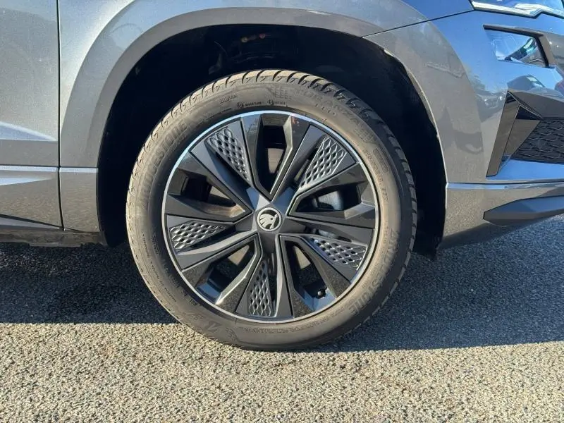 Gros plan sur la roue avant droite gris perle d'un Skoda Karoq 2025 avec jante alu noire au design moderne.