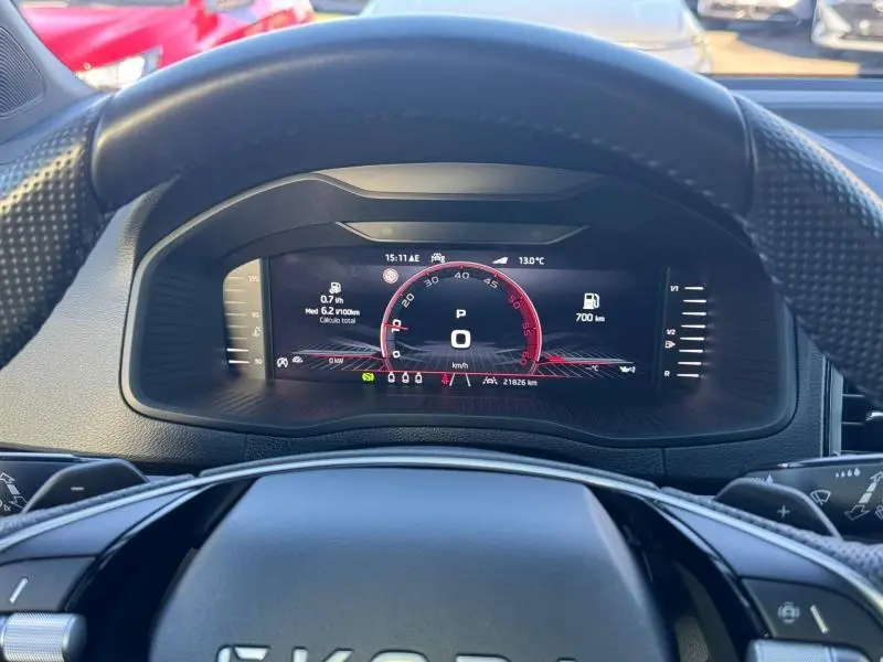 Vue rapprochée du tableau de bord numérique du Skoda Karoq gris, affichant la vitesse et l'autonomie.