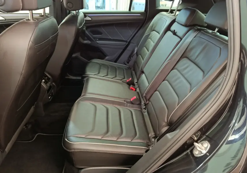 Vue côté droit des sièges arrière en cuir noir du Volkswagen Tiguan 1.4 eHybrid 2023 avec ceinture de sécurité visible.