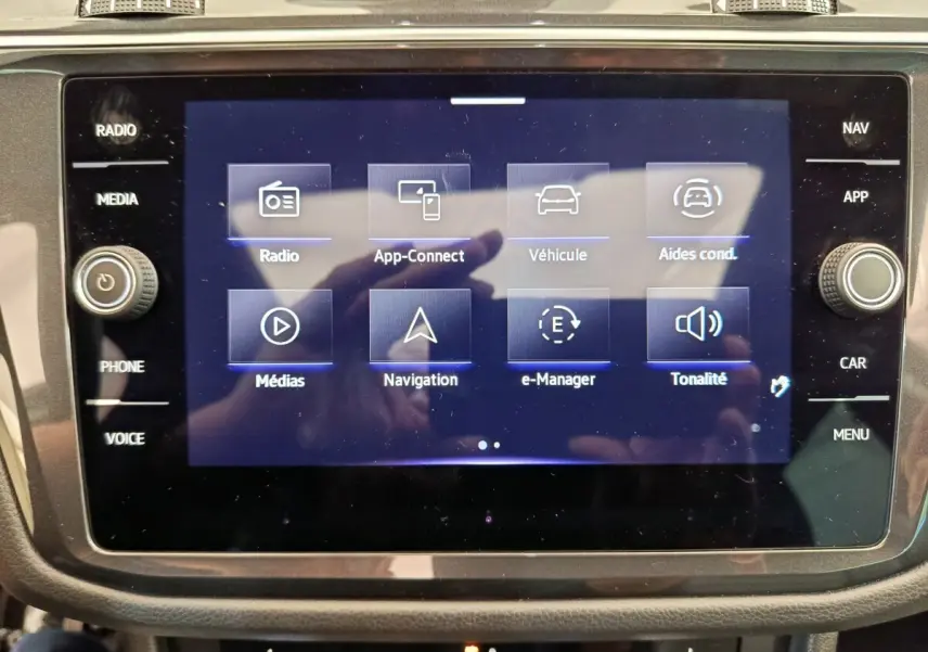 Écran tactile central du Volkswagen Tiguan 2023 affichant les options radio, navigation et aides à la conduite.