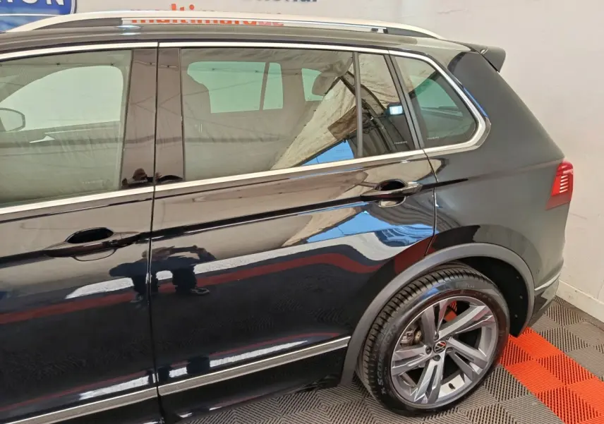 Vue latérale droite du Volkswagen Tiguan noir 1.4 eHybrid 2023 avec jantes alliage et détails chromés sur les portes.