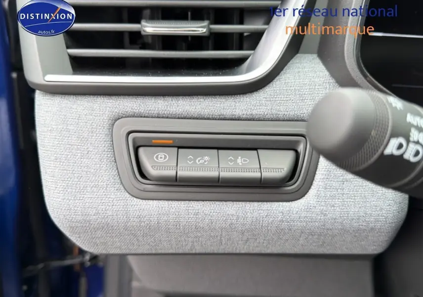 Détail des commandes d’éclairage et verrouillage sur panneau gris clair intérieur d’une Renault Clio V Bleu Iron.