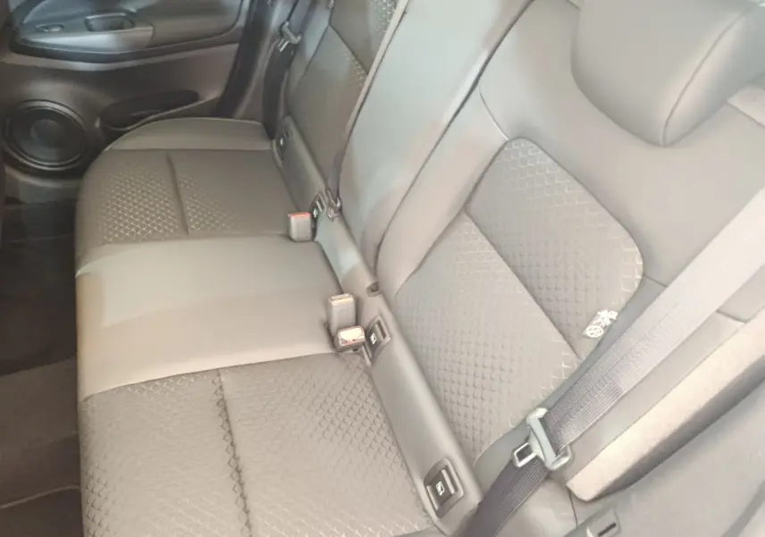 Vue rapprochée de la banquette arrière grise du Nissan Juke 2025, montrant les ceintures et fixations Isofix.