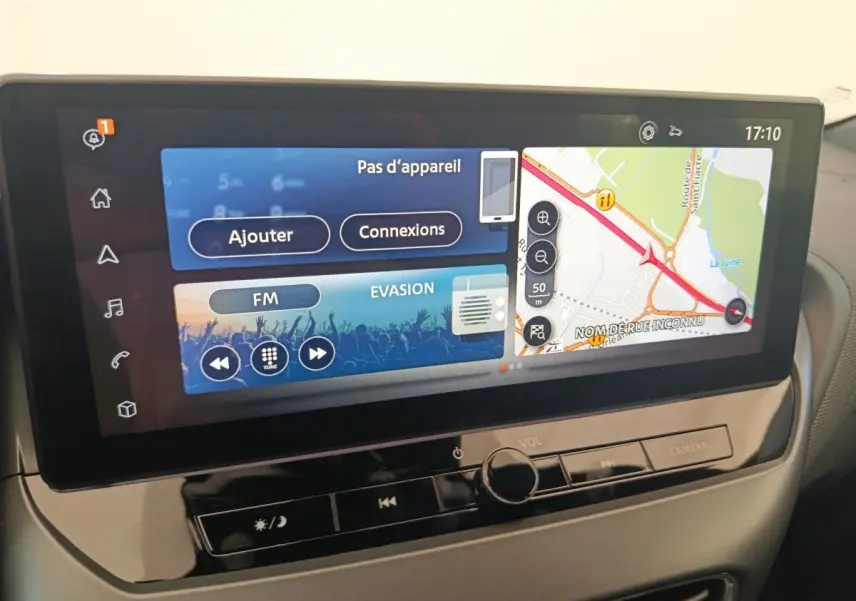 Écran tactile central 12,3 pouces du Nissan Juke bleu 2025 affichant navigation et radio FM en intérieur.