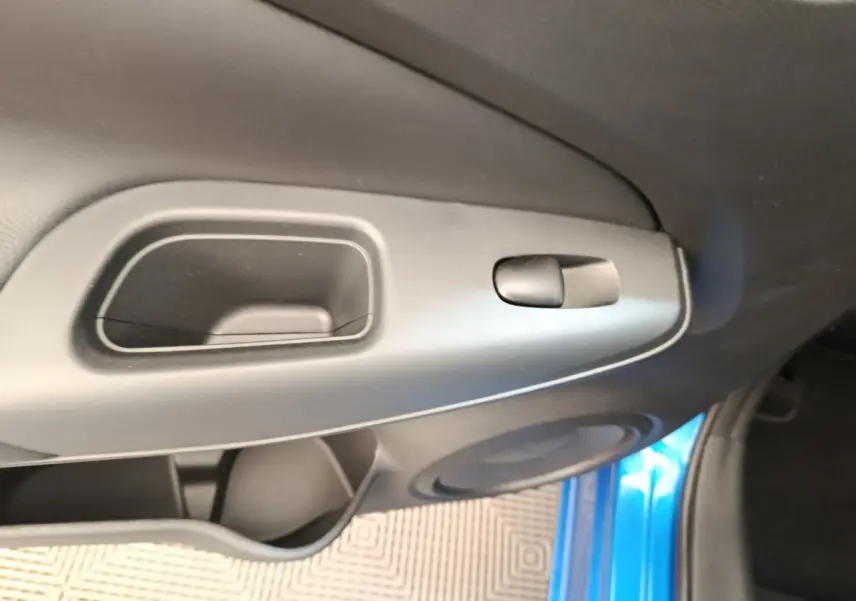 Poignée intérieure et commande de verrouillage sur la porte côté gauche d’un Nissan Juke bleu, vue rapprochée.