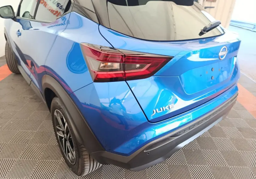 Vue 3/4 arrière droite du Nissan Juke bleu 2025 avec feux arrière LED et jantes alliage noires.