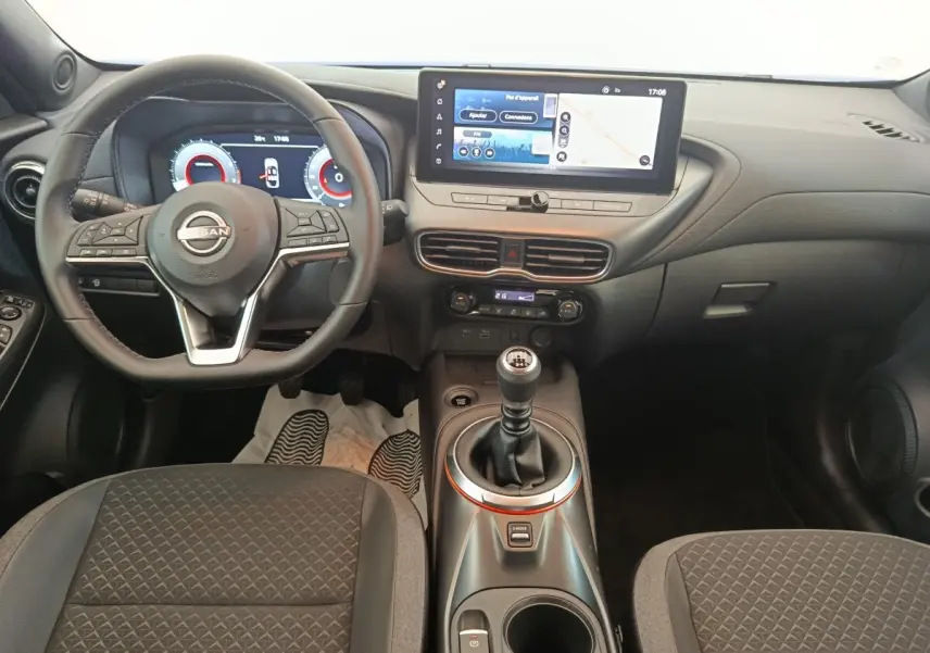 Intérieur noir du Nissan Juke 2025, vue de face sur le volant, tableau de bord digital et levier de vitesse manuel.