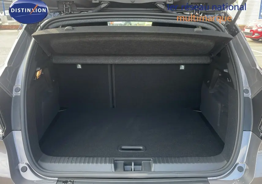 Coffre ouvert du Renault Captur E-Tech hybride 2025 gris Cassiopée métal, vue arrière montrant l'espace de chargement vide.