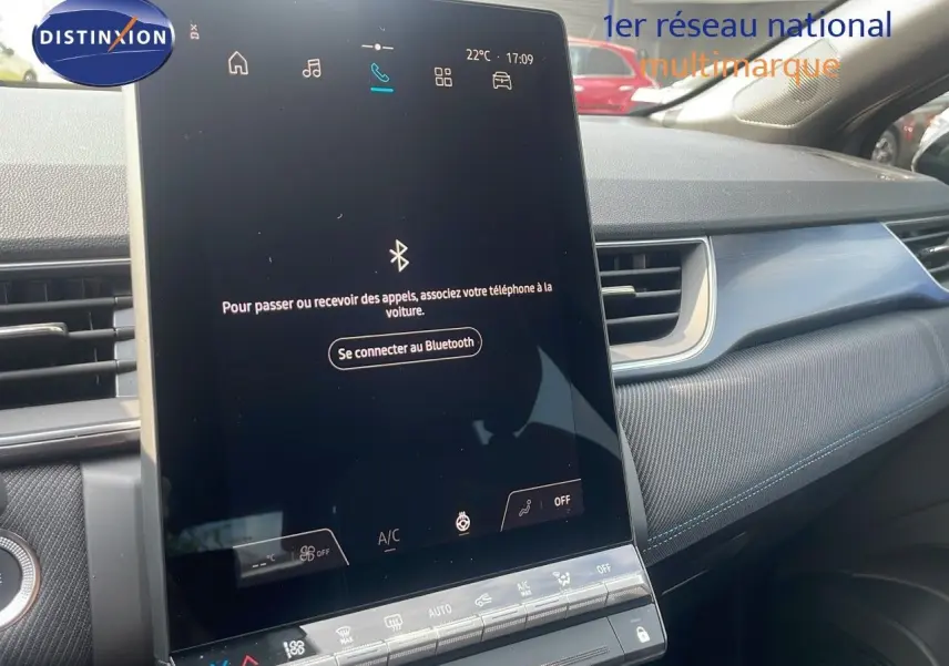 Vue intérieure du tableau de bord du Renault Captur gris Cassiopée, avec écran tactile central et garniture tissu bleu.