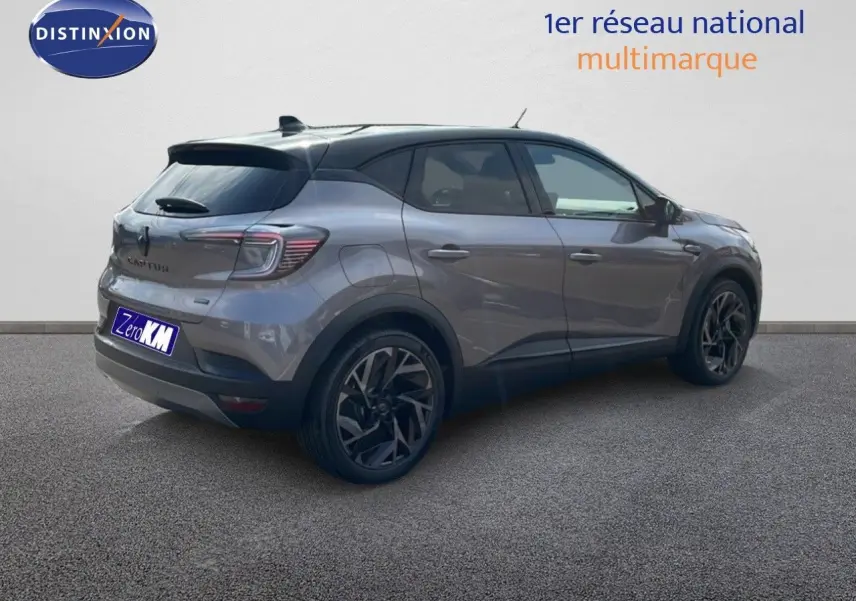 Vue 3/4 arrière droite d'un Renault Captur gris Cassiopée métal avec toit noir et jantes noires stylées.