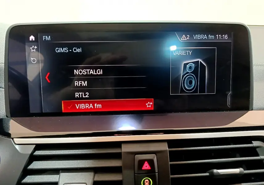 Écran tactile multimédia affichant les stations radio dans l'habitacle d'une BMW X3 noir, version Luxury 2019.