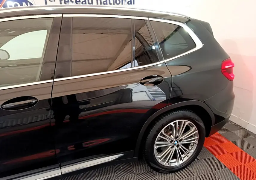Vue latérale droite du BMW X3 noir 2019 mettant en valeur les jantes alliage et les contours chromés des vitres.