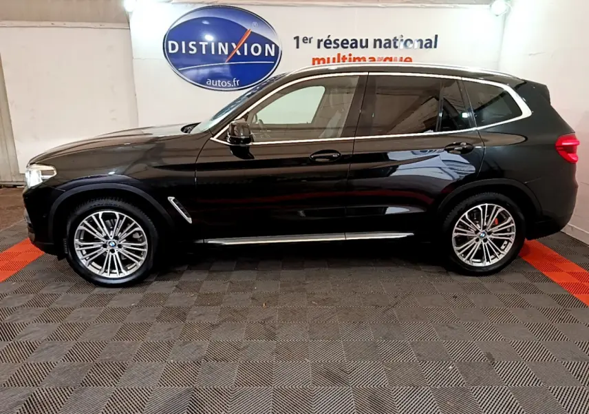 BMW X3 xDrive20d noir vu de profil côté gauche, avec jantes alliage et vitres teintées dans un showroom.