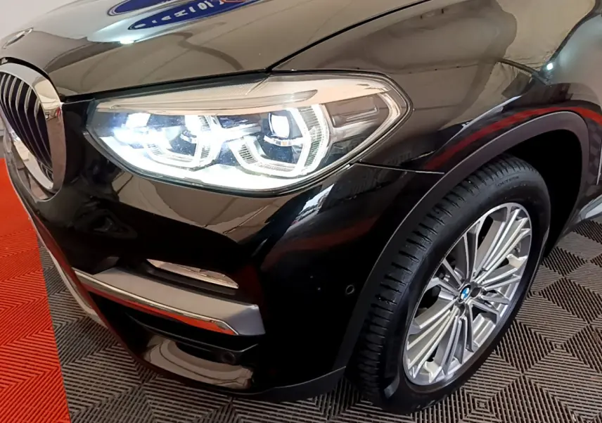 Gros plan sur l'avant droit noir d'un BMW X3 2019, mettant en valeur le phare LED et la jante alliage.