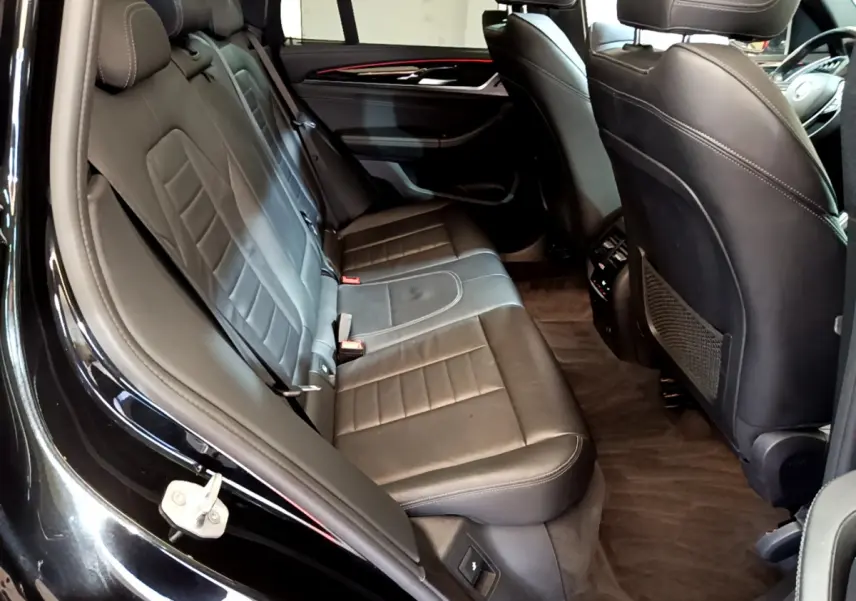 Vue intérieure côté gauche des sièges arrière en cuir noir du BMW X3 xDrive20d 2019 avec finitions élégantes et espace généreux.