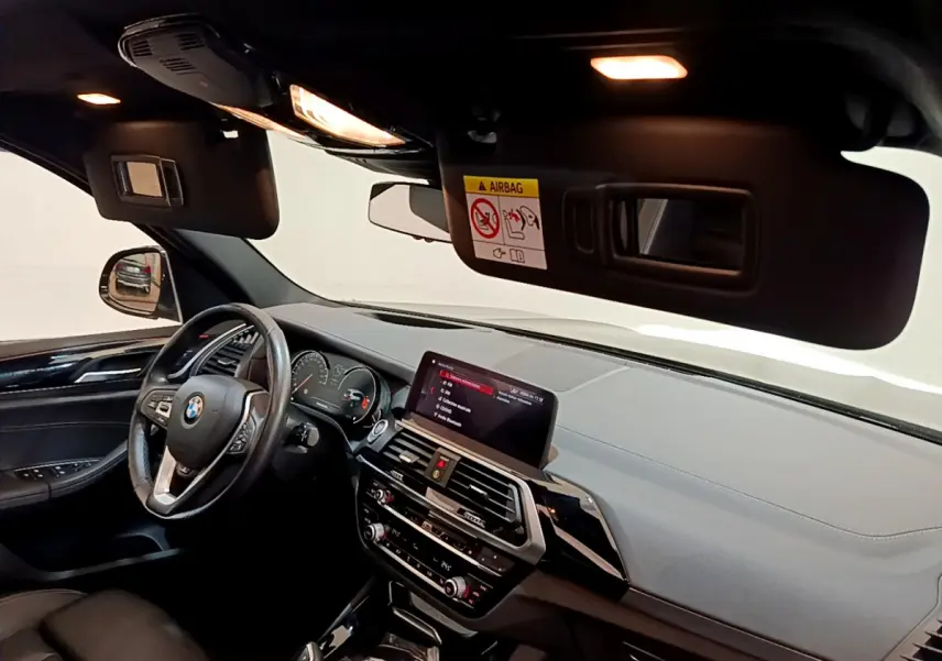 Intérieur noir de BMW X3 xDrive20d 2019, vue côté conducteur sur tableau de bord et écran tactile central.