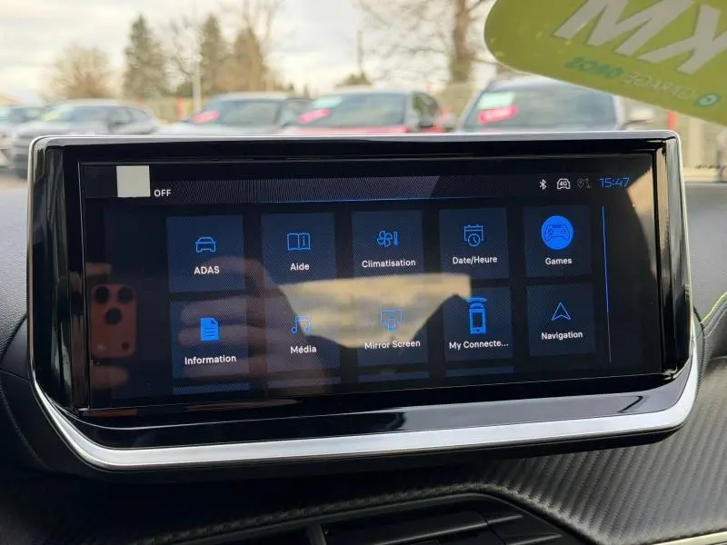 Écran tactile central du tableau de bord du Peugeot 2008 bleu, affichant les options multimédia et assistance.