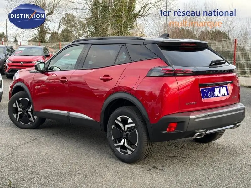 Vue 3/4 arrière droite d'un Peugeot 2008 rouge avec toit noir et jantes noires, garé en extérieur.