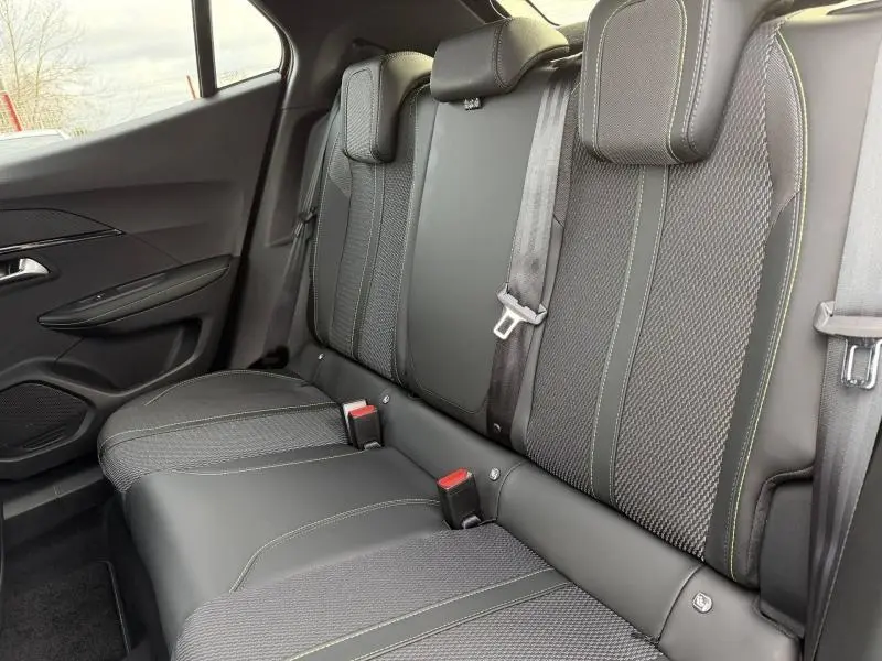 Vue latérale gauche de la banquette arrière noire avec surpiqûres vertes du Peugeot 2008 Hybrid 2025.