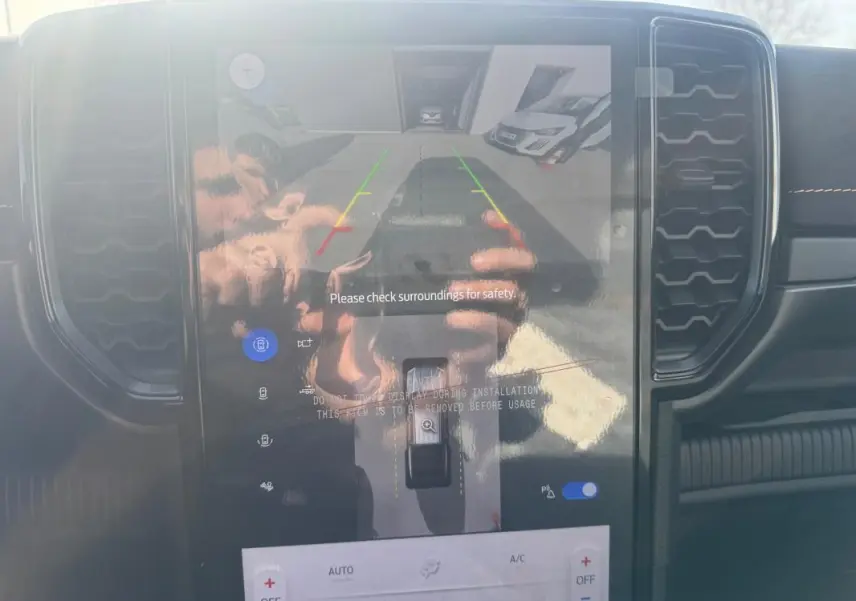 Vue intérieure du tableau de bord du Ford Ranger 2025, écran tactile affichant la caméra de recul avec commandes tactiles visibles.