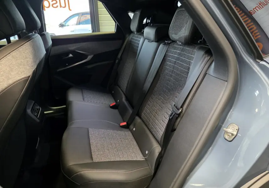 Vue intérieure côté droit sur la banquette arrière en tissu gris et cuir noir du Peugeot 3008 bleu clair 2025.