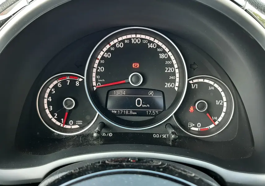 Vue rapprochée du tableau de bord noir du Volkswagen New Beetle 2015, affichant compteur, compte-tours et jauge carburant.