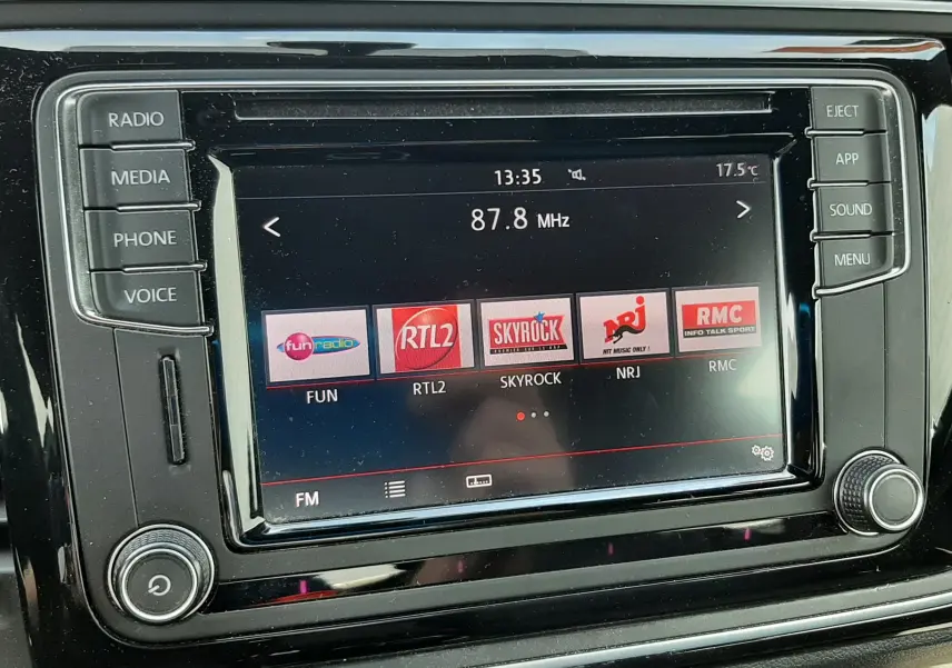 Écran tactile central noir du Volkswagen New Beetle 2015 affichant des stations radio FM à 87,8 MHz.