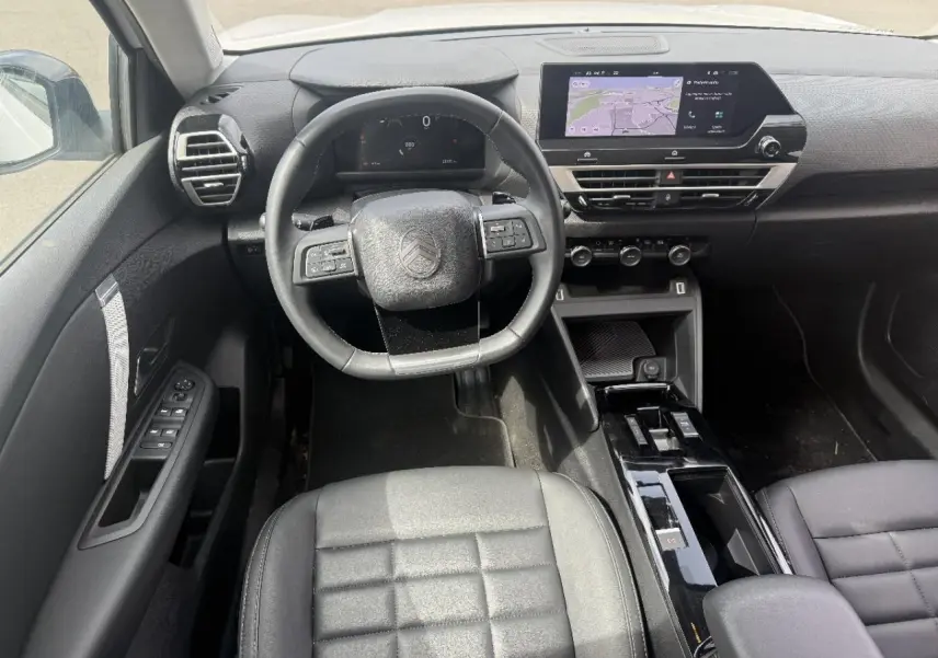 Vue intérieure frontale du poste de conduite de la Citroën C4 2025 avec tableau de bord numérique et écran tactile central.