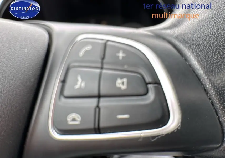 Gros plan sur les commandes multifonctions au volant d'une Mercedes Classe C gris alu de 2017.