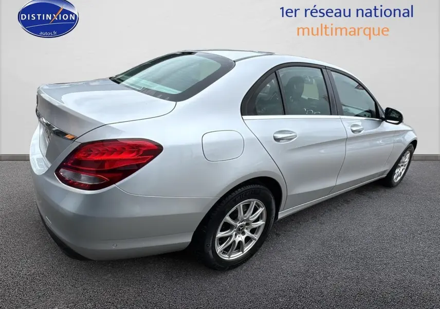 Mercedes Classe C 180 d business gris alu vue 3/4 arrière droit, jantes alliage et feux arrière rouges visibles.