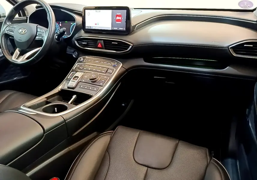 Vue intérieure du tableau de bord et console centrale du Hyundai Santa Fe 2022 avec écran tactile et finition cuir noire.