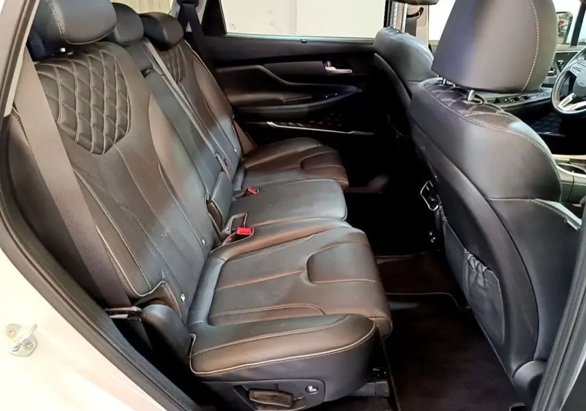 Vue intérieure côté gauche montrant la banquette arrière en cuir noir du Hyundai Santa Fe blanc 2022, finition Executive.