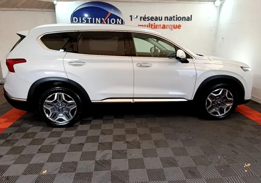 Vue de profil côté gauche d'un Hyundai Santa Fe blanc 7 places avec jantes alliage et vitres teintées.