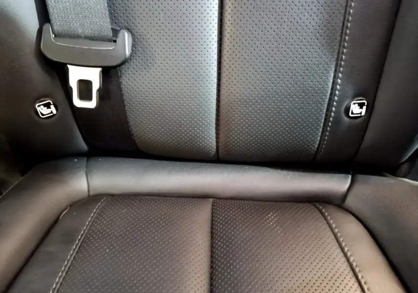 Gros plan sur la banquette arrière en cuir noir du Hyundai Santa Fe, montrant les fixations Isofix et la ceinture de sécurité.